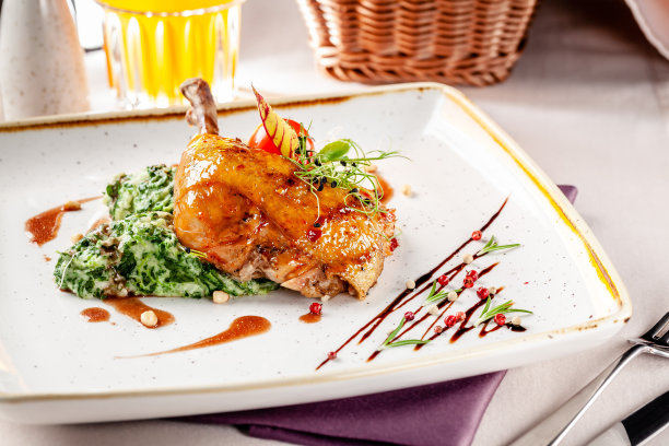 日本餐厅晚餐的概念。菠菜配以奶油和上釉的辣酱鸡腿。一杯李子酒。的背景图片。本空间图片下载