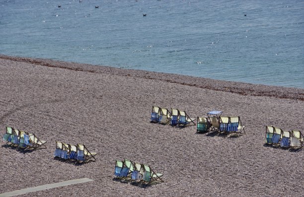 阳光英语海滩;空的躺椅-海湾和海岸啤酒在德文，英格兰西南部图片下载