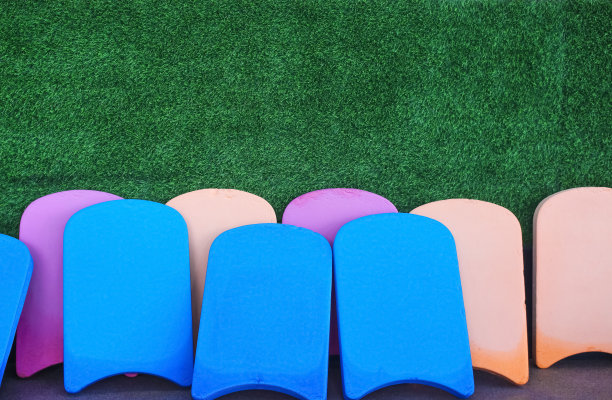 旧踢板和潮湿的人工绿草墙背景图片下载