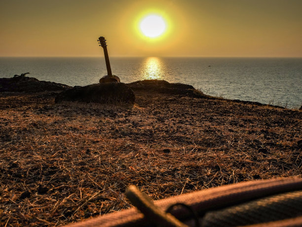 日落时吉他的剪影，印度戈卡纳。图片下载
