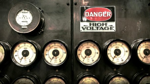 大型瓦特表和几个安培表上的工业墙上有一个“危险高电压”的标志图片下载