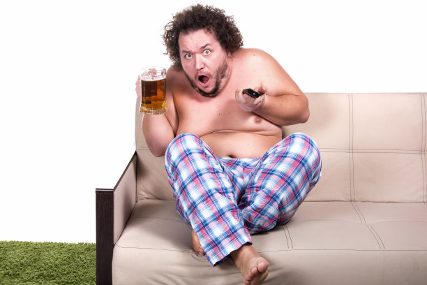 有趣的胖子在家里看电视。图片下载