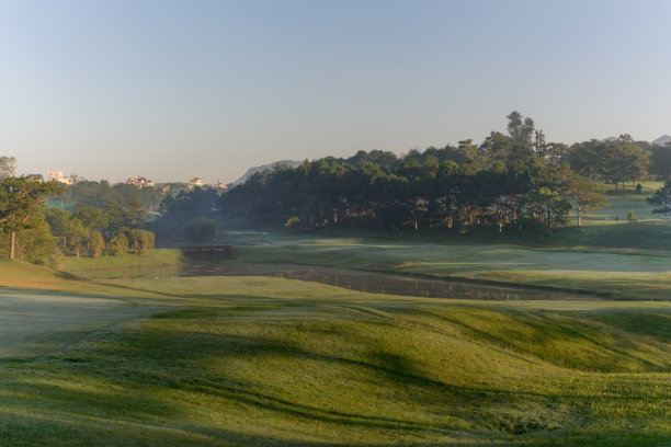 大自然有着神奇的阳光、阳光、绿油油的草地。照片用于高尔夫球的创意设计，清新的环境图片下载