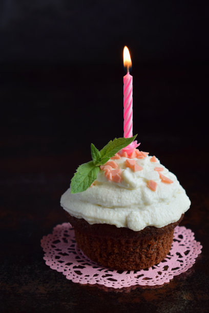 巧克力蛋糕加香草奶油和蜡烛。生日快乐。黑暗的照片图片下载