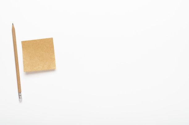 牛皮纸贴纸与铅笔在白色背景。的办公桌上,文具。复制空间，俯视图，平铺。图片下载