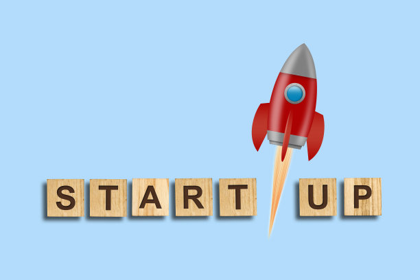 概念启动。木块上的题词和蓝色背景上的红色火箭。概念技术启动项目。业务。图片下载