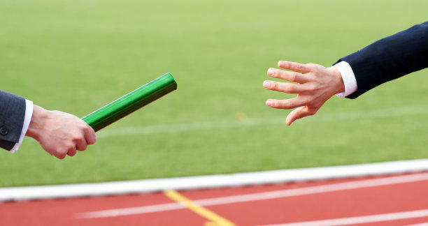 商人在接力赛中传递绿色接力棒图片下载
