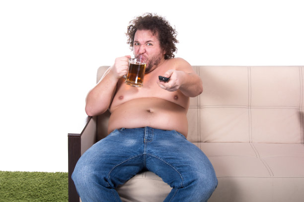 有趣的胖子在家里看电视。图片下载