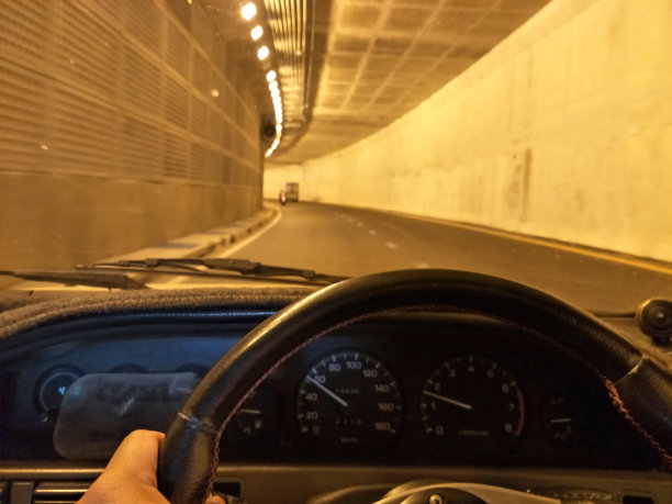 双手驾驶着一辆车，上了方向盘，上了柏油路。图片下载