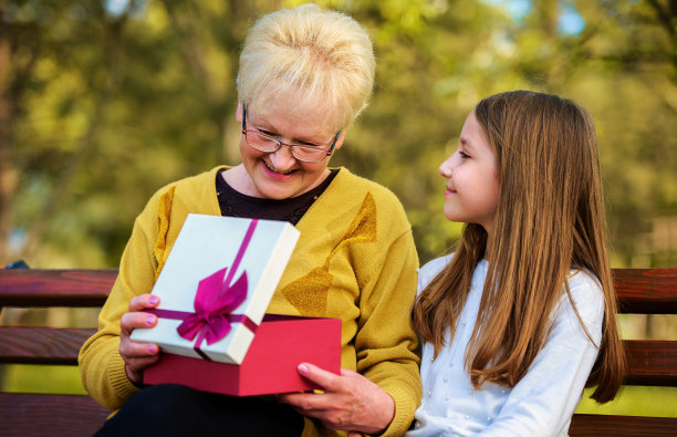 孙女在公园里给了奶奶一份生日礼物，让她很惊喜。的生活方式、家庭观念图片下载