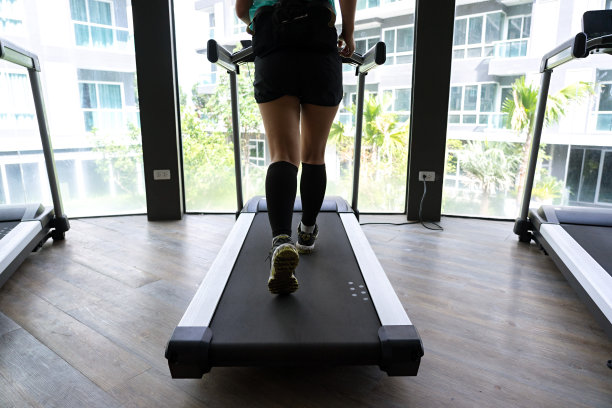 在跑步机上跑步的亚洲女人与明亮的建筑背景图片下载