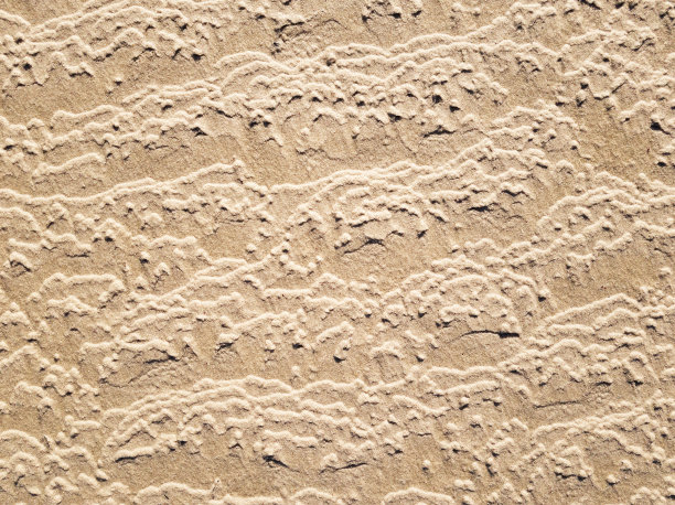 海滩上的潮汐图案作为自然背景图片下载