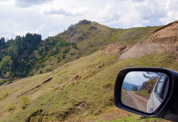 汽车的后视镜上映出一条山路图片下载