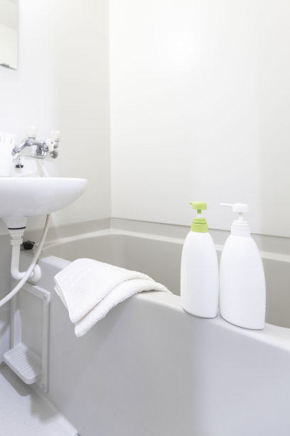 将洗发香波和沐浴皂瓶放入白色浴缸中图片下载