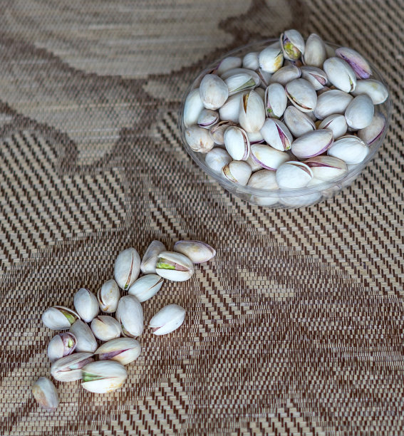 健康的食物背景图片近距离开心果。俯视图果仁开心果在杯盘上图片下载