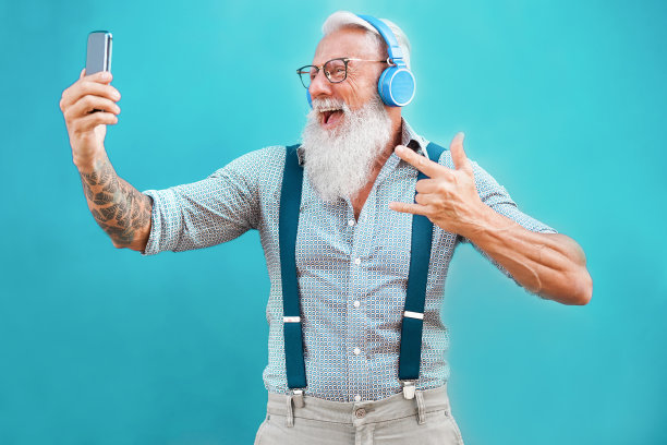 高级潮人使用智能手机应用程序创建播放列表的摇滚音乐-时尚纹身的人与手机技术的乐趣-科技和快乐的老年人生活理念-专注于脸图片下载