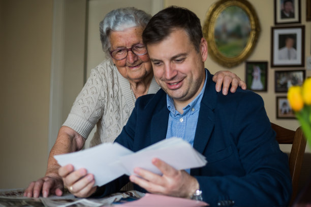 奶奶给成年的孙子看旧照片图片下载