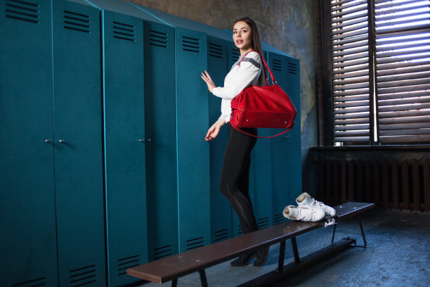 女孩溜冰与花样滑冰鞋和运动包。更衣室里的年轻美女图片下载