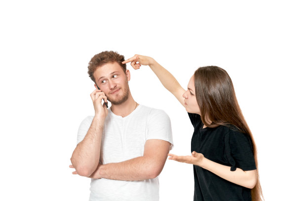 一对夫妇吵架的照片。一个愤怒的女人在男人打电话时对他大喊大叫。图片下载