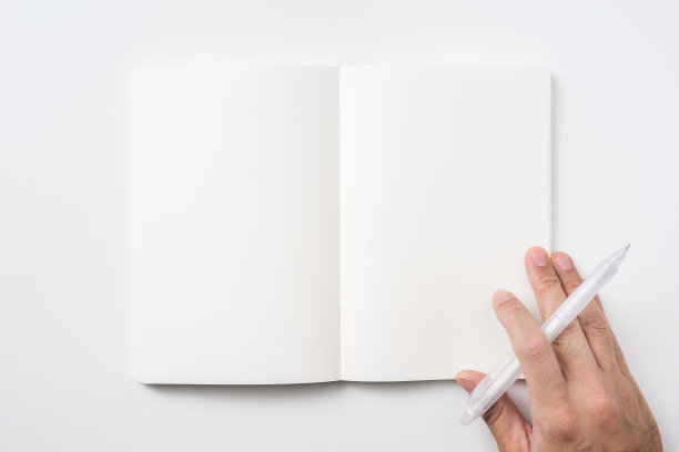 男子手持笔和黑色笔记本的背景图片下载