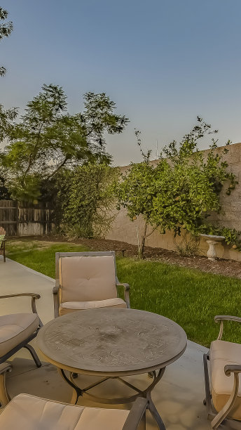 房子中庭上的垂直框架圆桌和带垫子的扶手椅图片下载