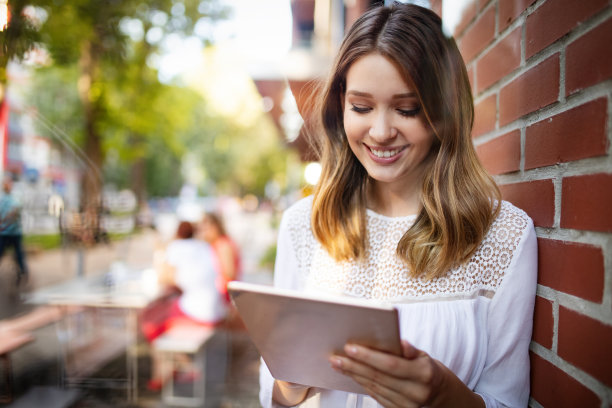 漂亮的黑发女孩使用平板电脑工作，自由职业，博客，学习，购物图片下载