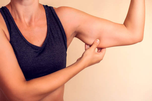 女人摸了摸她的三头肌。人、保健、美容的理念图片下载