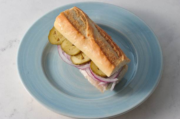 传统的鲱鱼三明治。法棍鲱鱼片，腌黄瓜片，洋葱圈。图片下载