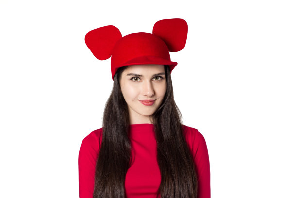 白色的黑发漂亮的年轻女子戴着红色可爱的老鼠耳朵的帽子图片下载