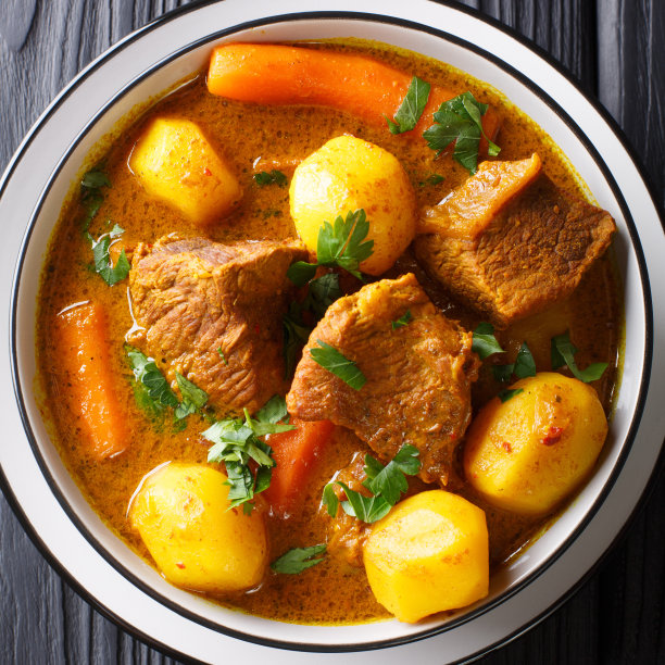 美味的有机非洲羊肉炖菜与蔬菜近距离在一个碗。垂直的俯视图图片下载
