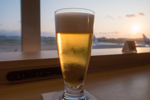 玻璃啤酒在夕阳下闪闪发光。图片下载