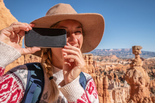 年轻女子用智能手机拍摄布莱斯峡谷图片下载
