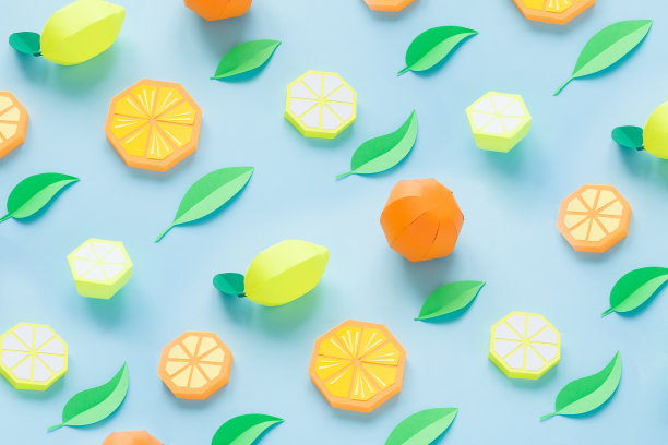 纸做的水果。蓝色背景。有写作的空间。热带地区。平的。橙、柠檬。图片下载