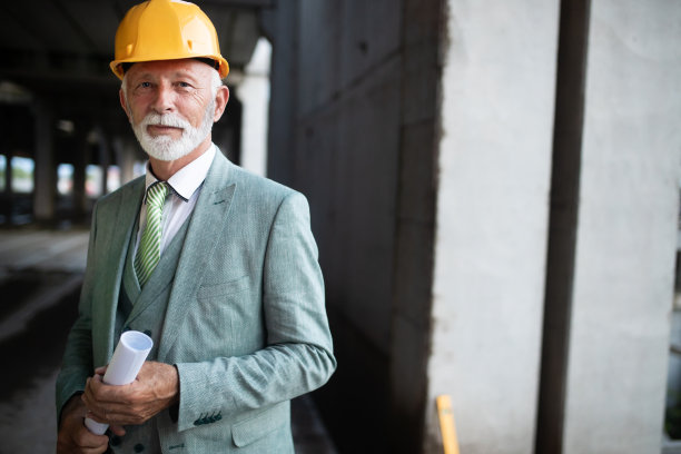 微笑的施工经理，工程师，商人，建筑师站在施工现场图片下载