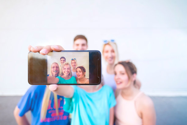 一群年轻人在用手机自拍图片下载