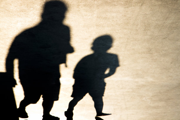 一个男孩和一个成年人走路的模糊影子图片下载