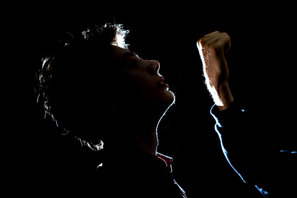 黑暗中拳打在男性脸上的剪影轮廓图片下载