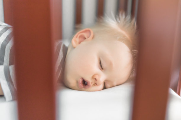 小男孩睡在婴儿床里图片下载