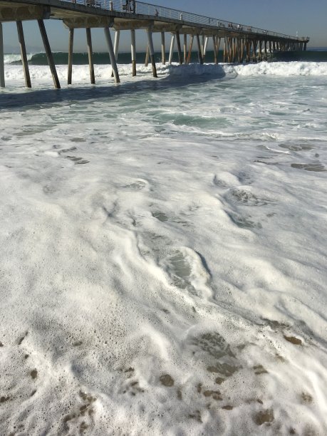 起泡的波浪覆盖着码头下的沙子图片下载