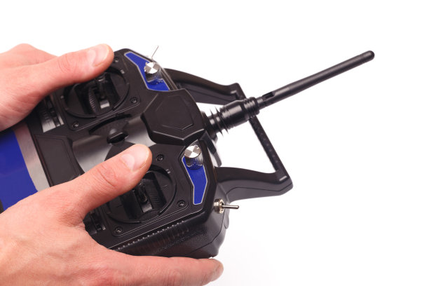 人的手拿着遥控器与操纵杆和天线隔离在白色背景-图像图片下载