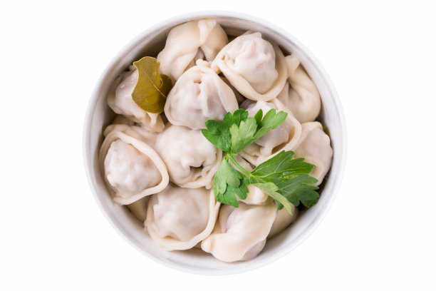 自制的肉饺子。有月桂叶和欧芹的俄罗斯佩尔梅尼，在一个碗里，孤立在白色的背景上。前视图。图片下载