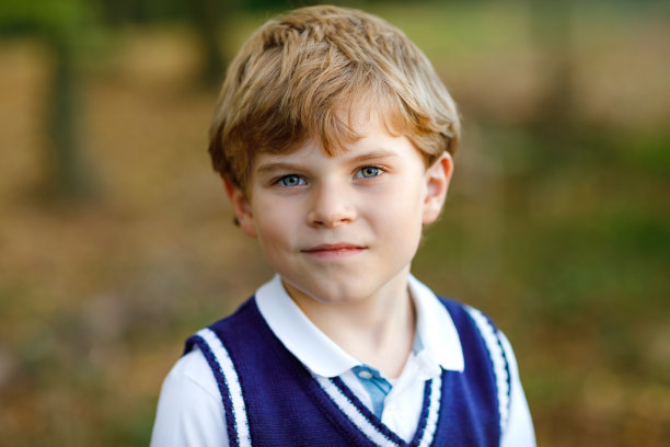 森林里酷酷的小男孩的肖像。快乐健康的孩子有乐趣在温暖的阳光初秋的一天。家庭、自然、爱和积极的休闲。穿校服的孩子。图片下载