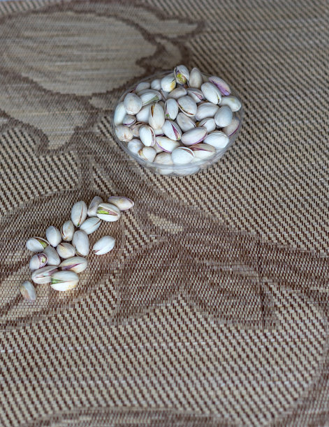 健康的食物背景图片近距离开心果。俯视图果仁开心果在杯盘上图片下载