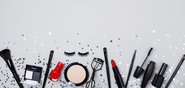 美容产品和化妆品的女人化妆装饰星形五彩纸屑在灰色的桌子顶视图和平lay。横幅的格式。图片下载