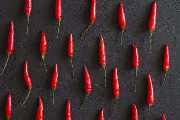 红辣椒在黑色的黑色背景在黑色的桌子上。很多红辣椒。为你的文本复制空间。平躺，俯视图。有节奏的影像，照片或物体的重复图片下载