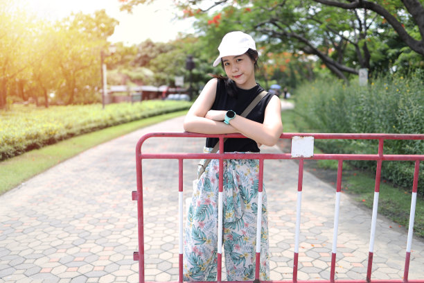 亚洲少女戴着一顶帽子站着拍照图片下载