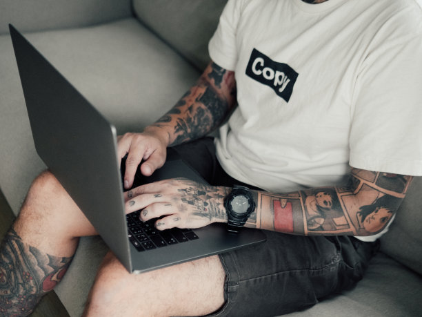 年轻的亚洲人在沙发上使用笔记本电脑。图片下载