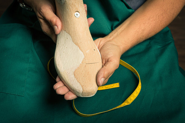 矫形鞋匠检查手工木鞋楦的表面图片下载