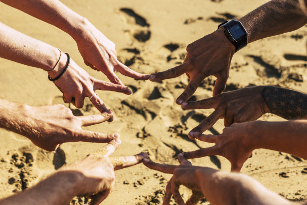 团队合作、友谊共进的理念与一群白种人青年携手做胜利的标志，在夏日的阳光下——朋友与青春永远团结图片下载