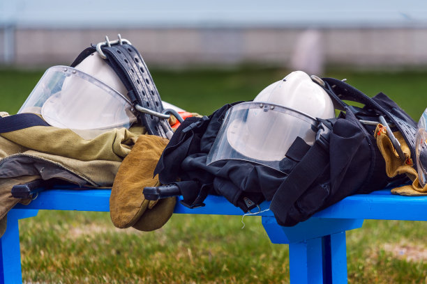 穿着制服的救援人员和消防员躺在露天的长凳上。愿意完成任务。图片下载